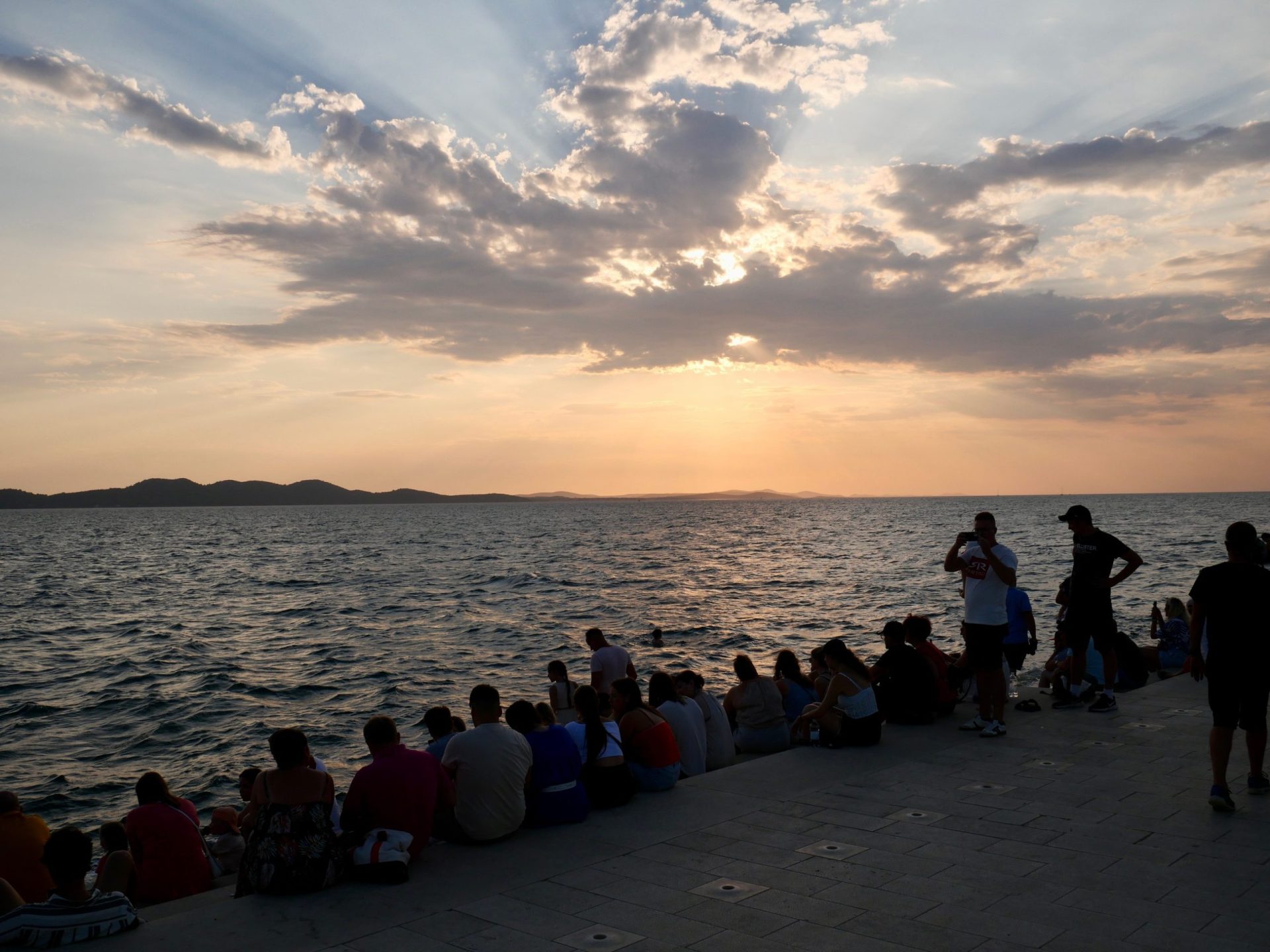 mensen wachten op de mooiste zonsondergang in Zadar